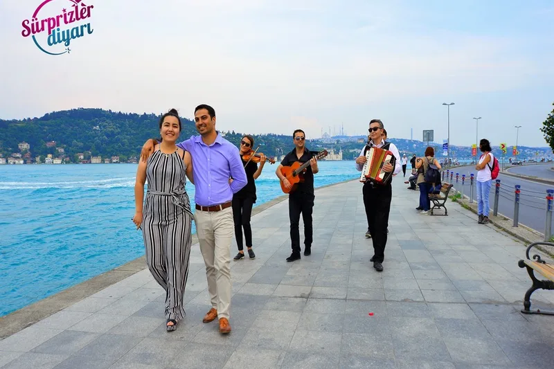 Boğaz sahilinde yürüyen çiftin arkasında onları takip eden gitarist kemancı ve akordeon sanatçısı